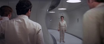 Movie still from “The Andromeda Strain” (1971), directed by Robert Wise – A man standing in a tunnel with a woman looking at him; Wide shot, Low angle