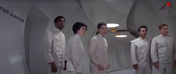 Movie still from “The Andromeda Strain” (1971), directed by Robert Wise – A group of people standing next to each other in a room; Medium shot, Low angle
