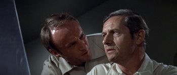 Movie still from “The Andromeda Strain” (1971), directed by Robert Wise – A man and another man looking at one another; Close Up shot, Over the shoulder angle
