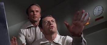 Movie still from “The Andromeda Strain” (1971), directed by Robert Wise – Two men in white shirts looking up at something in the air; Close Up shot, Low angle