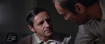 Movie still from “The Andromeda Strain” (1971), directed by Robert Wise – Two men talking to each other in the dark; Close Up shot, Over the shoulder angle