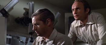 Movie still from “The Andromeda Strain” (1971), directed by Robert Wise – A man with a shaved head and a man with a goatee; Close Up shot, Low angle