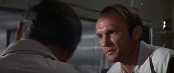 Movie still from “The Andromeda Strain” (1971), directed by Robert Wise – A person in a room near a wall; Close Up shot, Over the shoulder angle