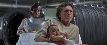 Movie still from “The Andromeda Strain” (1971), directed by Robert Wise – An older man holding a baby in a hospital bed; Medium shot, Low angle