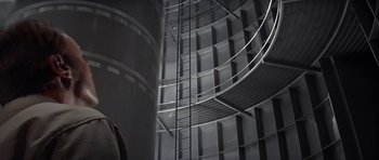 Movie still from “The Andromeda Strain” (1971), directed by Robert Wise – A spiral stair case in a large building; Medium shot, Low angle