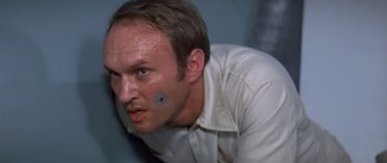 Movie still from “The Andromeda Strain” (1971), directed by Robert Wise – A person wearing a white shirt; Close Up shot, Low angle