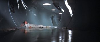 Movie still from “The Andromeda Strain” (1971), directed by Robert Wise – A person laying on the ground in a tunnel; Wide shot, High angle