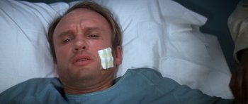 Movie still from “The Andromeda Strain” (1971), directed by Robert Wise – A man laying in a hospital bed with bandages on his face; Close Up shot, High angle