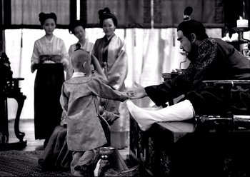 Movie still from “The Assassin” (2015), directed by Hsiao-Hsien Hou – A young boy and a group of people dressed in traditional asian garb; Medium shot, Low angle