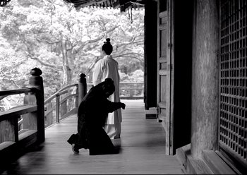 Movie still from “The Assassin” (2015), directed by Hsiao-Hsien Hou – Two women in traditional garb are standing on a porch; Wide shot, Low angle