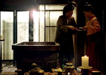 Movie still from “The Assassin” (2015), directed by Hsiao-Hsien Hou – Two women are standing in front of an urn; Medium shot, Low angle