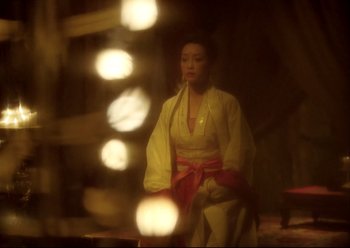 Movie still from “The Assassin” (2015), directed by Hsiao-Hsien Hou – A woman in a yellow and red kimono is smoking a cigarette; Medium shot, Over the shoulder angle