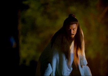 Movie still from “The Assassin” (2015), directed by Hsiao-Hsien Hou – A woman with long brown hair standing in the dark; Medium shot, Low angle