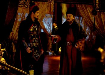 Movie still from “The Assassin” (2015), directed by Hsiao-Hsien Hou – Two men dressed in medieval clothing talking to each other; Medium shot, Over the shoulder angle
