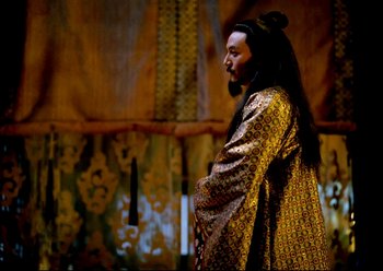Movie still from “The Assassin” (2015), directed by Hsiao-Hsien Hou – A man with long black hair wearing a gold robe; Medium shot, Low angle