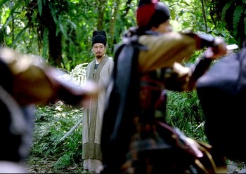 Movie still from “The Assassin” (2015), directed by Hsiao-Hsien Hou – A man standing in the middle of a forest; Medium shot, Over the shoulder angle