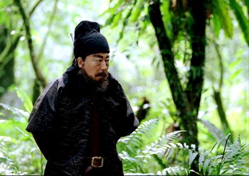 Movie still from “The Assassin” (2015), directed by Hsiao-Hsien Hou – A man in a black hat and a black coat; Medium shot, Low angle