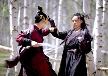 Movie still from “The Assassin” (2015), directed by Hsiao-Hsien Hou – Two people in costumes are fighting in the woods; Medium shot, Over the shoulder angle