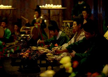 Movie still from “The Assassin” (2015), directed by Hsiao-Hsien Hou – A group of people sitting at a table eating food; Wide shot, High angle