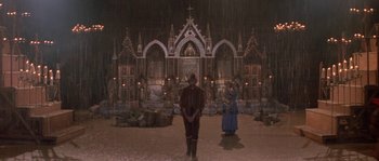 Movie still from “The Baby of Mâcon” (1993), directed by Peter Greenaway – A man and a woman standing in front of a church; Wide shot, High angle