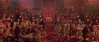 Movie still from “The Baby of Mâcon” (1993), directed by Peter Greenaway – A group of people sitting in a room with candles; Extreme Wide shot, High angle