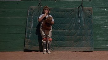 Movie still from “The Bad News Bears” (1976), directed by Michael Ritchie – A baseball player is sitting on the ground with a glove in his hand; Wide shot, High angle