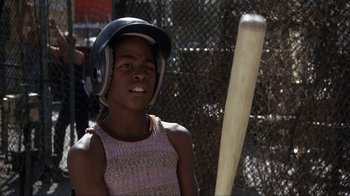 Movie still from “The Bad News Bears” (1976), directed by Michael Ritchie – A young girl wearing a helmet and holding a baseball bat; Close Up shot, Over the shoulder angle