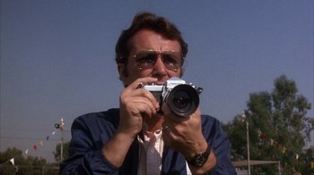 Movie still from “The Bad News Bears” (1976), directed by Michael Ritchie – A man taking a picture with a camera; Close Up shot, Low angle