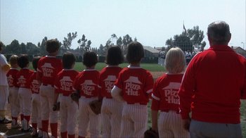 Movie still from “The Bad News Bears” (1976), directed by Michael Ritchie – A group of little league baseball players standing on top of a baseball field; Wide shot, Low angle