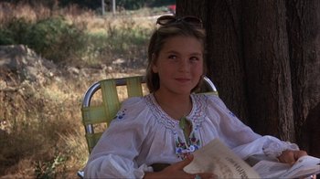 Movie still from “The Bad News Bears” (1976), directed by Michael Ritchie – A young girl sitting in a lawn chair holding a book; Close Up shot, Low angle