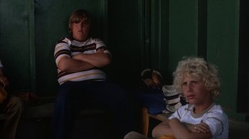 Movie still from “The Bad News Bears” (1976), directed by Michael Ritchie – Two young boys sitting on a chair in a room; Medium shot, Low angle