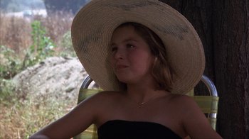 Movie still from “The Bad News Bears” (1976), directed by Michael Ritchie – A young girl wearing a straw hat sitting in a chair; Close Up shot, High angle
