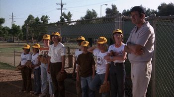 Movie still from “The Bad News Bears” (1976), directed by Michael Ritchie – A group of young baseball players standing next to each other on a baseball field; Medium shot, Low angle
