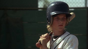 Movie still from “The Bad News Bears” (1976), directed by Michael Ritchie – A young boy holding a baseball bat and wearing a helmet; Close Up shot, Low angle