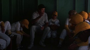 Movie still from “The Bad News Bears” (1976), directed by Michael Ritchie – A group of baseball players sitting next to each other; Medium shot, Low angle