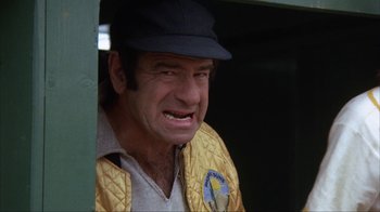 Movie still from “The Bad News Bears” (1976), directed by Michael Ritchie – An older man wearing a baseball cap and a yellow jacket; Close Up shot, Low angle