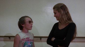 Movie still from “The Bad News Bears” (1976), directed by Michael Ritchie – Two people standing next to each other in front of a wall; Medium shot, Over the shoulder angle