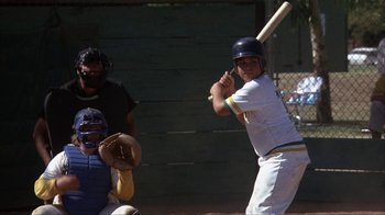 Movie still from “The Bad News Bears” (1976), directed by Michael Ritchie – A baseball player holding a baseball bat on a field; Medium shot, Low angle