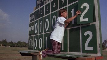 Movie still from “The Bad News Bears” (1976), directed by Michael Ritchie – A young man is leaning against a scoreboard; Medium shot, Low angle