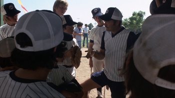Movie still from “The Bad News Bears” (1976), directed by Michael Ritchie – A group of baseball players standing next to each other on a field; Medium shot, Over the shoulder angle