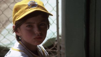 Movie still from “The Bad News Bears” (1976), directed by Michael Ritchie – A young boy wearing a baseball uniform and a hat; Close Up shot, Low angle