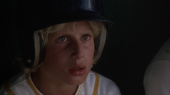 Movie still from “The Bad News Bears” (1976), directed by Michael Ritchie – A young boy wearing a baseball uniform and a helmet; Close Up shot, Low angle
