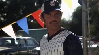Movie still from “The Bad News Bears” (1976), directed by Michael Ritchie – A man in a baseball uniform and a hat; Medium shot, Low angle