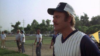 Movie still from “The Bad News Bears” (1976), directed by Michael Ritchie – A man in a baseball uniform stands on a baseball field; Close Up shot, Low angle