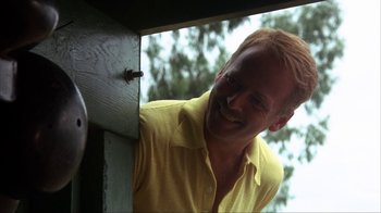 Movie still from “The Bad News Bears” (1976), directed by Michael Ritchie – A man in a yellow shirt leaning against a wall; Close Up shot, Low angle