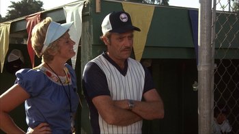 Movie still from “The Bad News Bears” (1976), directed by Michael Ritchie – A man and a woman standing next to each other in front of a tent; Medium shot, Over the shoulder angle