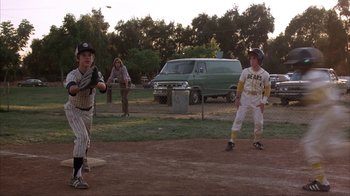 Movie still from “The Bad News Bears” (1976), directed by Michael Ritchie – A group of young men playing a game of baseball; Wide shot, Over the shoulder angle