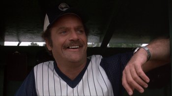 Movie still from “The Bad News Bears” (1976), directed by Michael Ritchie – A man in a baseball uniform sitting in a car; Close Up shot, Low angle