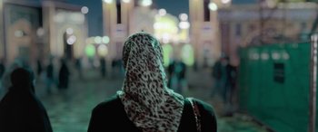 Movie still from “Holy Spider” (2022), directed by Ali Abbasi – A woman wearing a head scarf in front of a crowd; Close Up shot, Over the shoulder angle