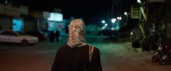 Movie still from “Holy Spider” (2022), directed by Ali Abbasi – A woman with a leopard print head scarf on; Close Up shot, Over the shoulder angle